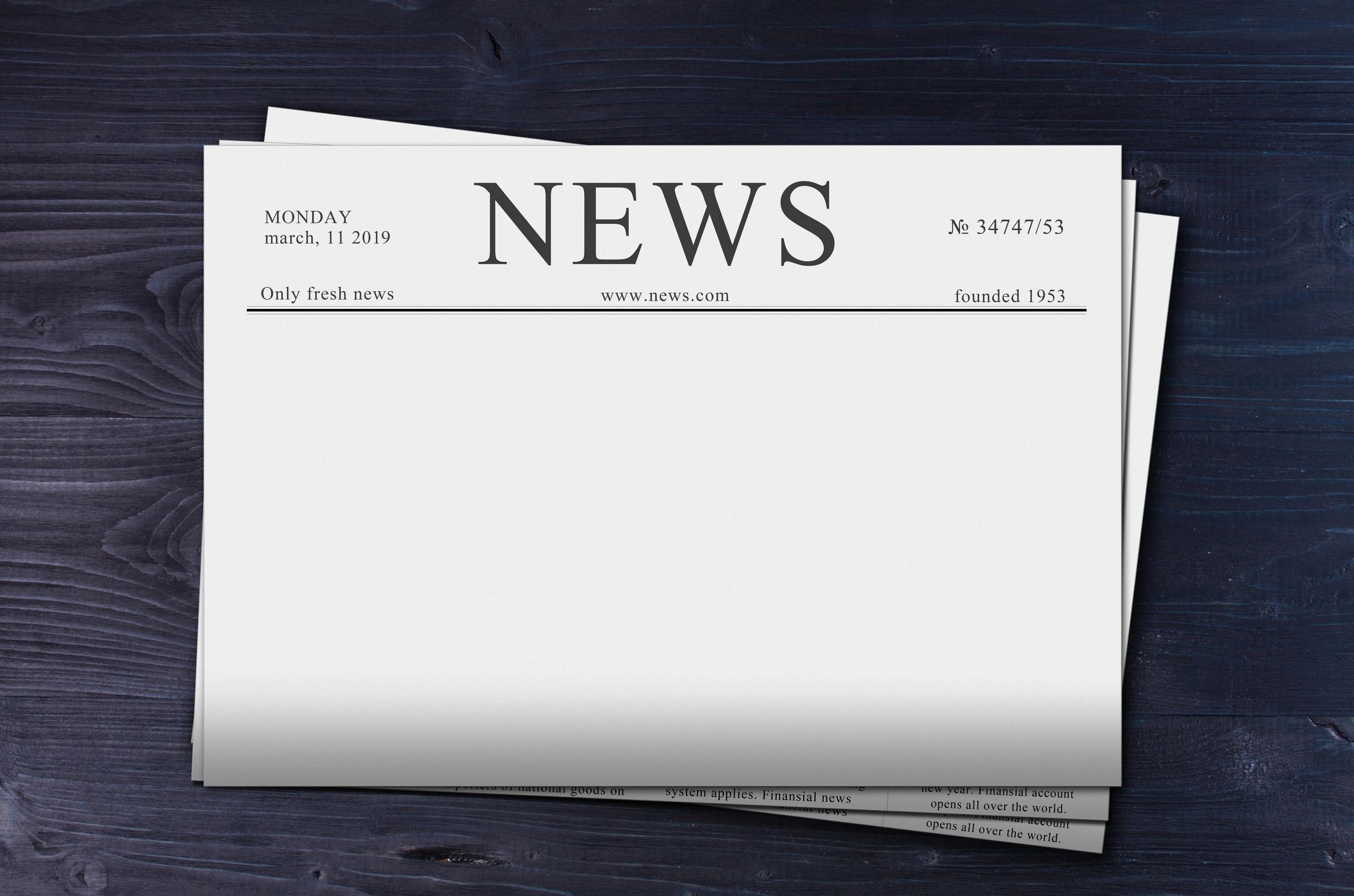 Newspapers laid out on a dark editorial desk